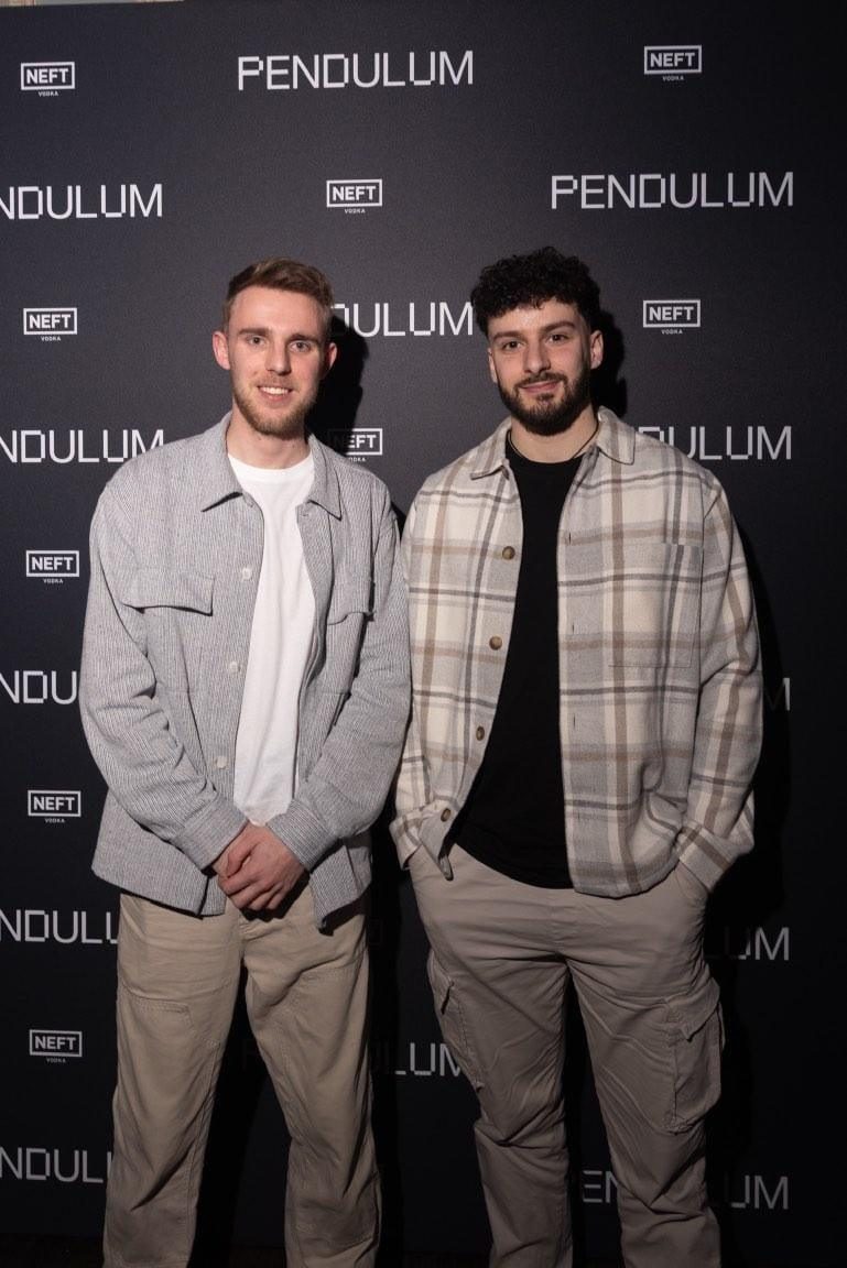 Ben and Hadrien side by side in front of a Pendulum event backdrop